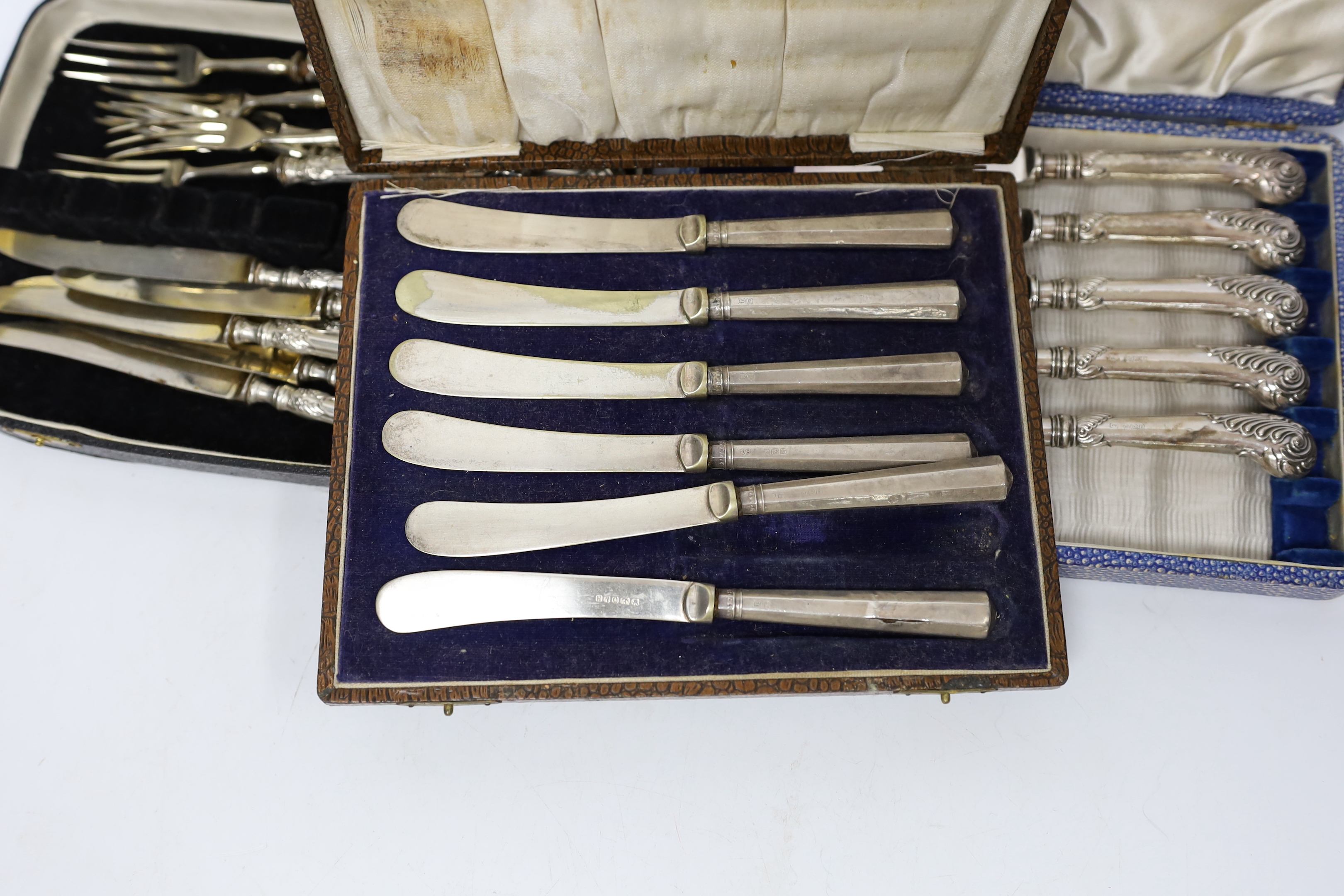 Six pairs of German Art Nouveau 800 standard white metal handled dessert eaters and two cased sets of six silver handled tea knives(one knife missing).
